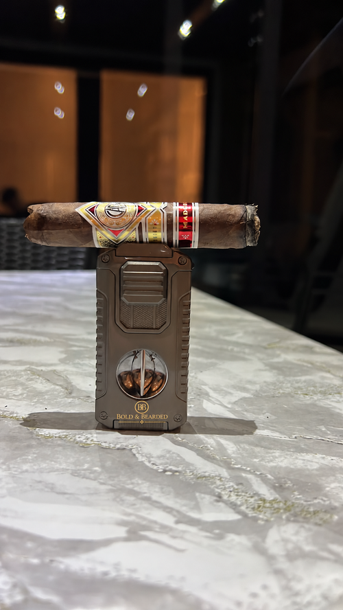 Silver / Gunmetal — Real-life table photograph with Bold & Bearded gold branding added; cigar shown for context (AI-edited photo)